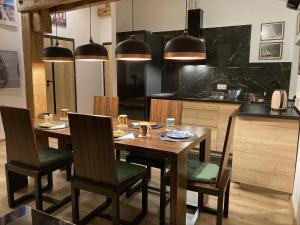 uma sala de jantar com mesa e cadeiras e uma cozinha em Komfortowy Apartament w Młynie Mrągowo em Mrągowo