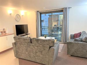 a living room with two couches and a tv at Mosh Homes 01 in Manchester