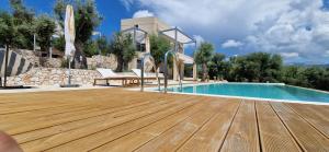 een zwembad met een houten terras naast een huis bij Villa Maya Lefkada in Évyiros