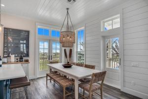 a dining room with a table and chairs and windows at Luxury townhome, steps to beach and resort fun! in Port Aransas