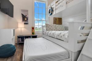 a white bedroom with a bed and a window at Luxury townhome, steps to beach and resort fun! in Port Aransas