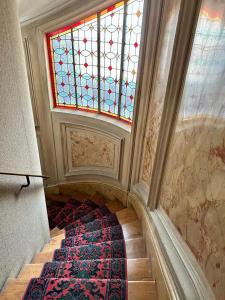 a staircase with a stained glass window and a rug at Appartement cosy - Sacré coeur in Paris