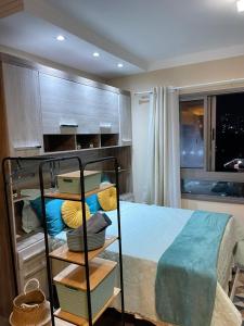 a bedroom with a bed and a shelf with pillows at Stúdio lindo no Tatuapé in São Paulo