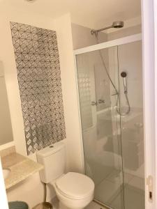 uma casa de banho com um WC e uma cabina de duche em vidro. em Stúdio lindo no Tatuapé em São Paulo