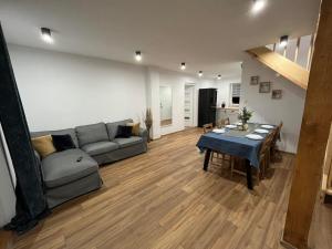 a living room with a couch and a table at Mazurska Osada Domki in Rydzewo