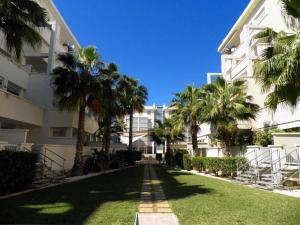 una calle con palmeras frente a un edificio en Residencial Elegance, en Denia