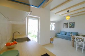 a kitchen and living room with a blue couch at Apartmani Porat Sali in Sali