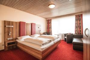 um quarto de hotel com uma cama e uma cadeira em Landgastohf Thiem em Waischenfeld