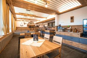 a restaurant with wooden tables and chairs in a room at Landgastohf Thiem in Waischenfeld