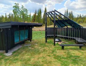 a bird sitting next to a playground with a swing at A cozy shelter in beautifull nature in Tisleidalen