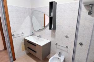 a bathroom with a sink and a mirror and a toilet at Il Giardino degli aranci in Pisciotta +24 photos