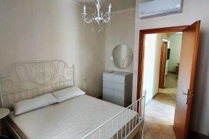 a bedroom with a bed and a mirror and a chandelier at Il Giardino degli aranci in Pisciotta