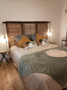 uma cama grande num quarto com duas luzes acesas em La Cressonnière 56 em Missiriac