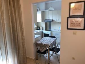 a kitchen with a table and two chairs and a table at Central Comfy Home in Kalamata