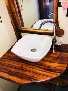 a white sink on a wooden counter with a mirror at Baby Rustic in Punta Rucia