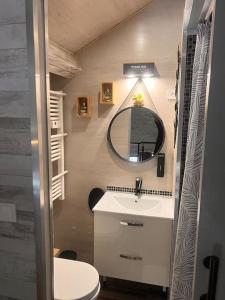 a bathroom with a sink and a mirror at Top Loft Perles 4 des Châteaux in Mer