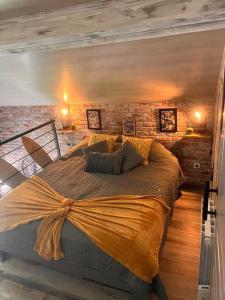 a bedroom with a large bed with a brick wall at Top Loft Perles 4 des Châteaux in Mer
