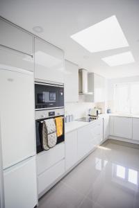 a white kitchen with white cabinets and an oven at Penthouse at Chelsea Cloisters Hotel in London