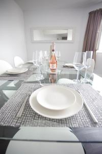 a dining table with a white plate and wine glasses at Penthouse at Chelsea Cloisters Hotel in London