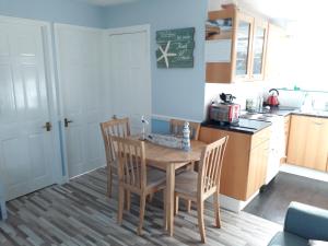 a kitchen with a table and chairs in a kitchen at Holiday at Hemsby in Hemsby