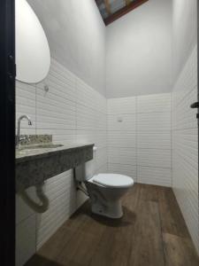 uma casa de banho branca com um WC e um lavatório em Sobrado para relaxar em Tatuí