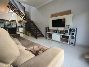 uma sala de estar com um sofá e uma televisão de ecrã plano em Sobrado para relaxar em Tatuí