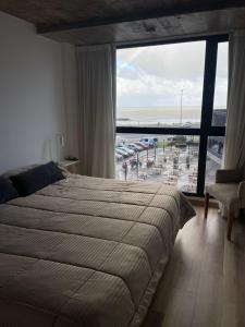 a bedroom with a bed and a view of a parking lot at Marmol y Constitución, con vista al mar in Mar del Plata