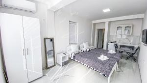 a white bedroom with a bed and a desk at Vila Shogun in Ohrid