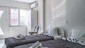 a bedroom with two beds and a chair at Vila Shogun in Ohrid