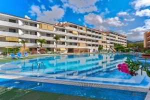 una gran piscina frente a un edificio en Perfect Holiday Sea View Top Floor LosCristianos en Los Cristianos