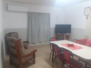 un soggiorno con tavolo, sedie e TV di Mi Casa por los Caminos del Vino 