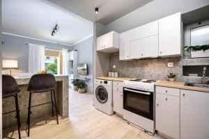 a kitchen with white cabinets and a dishwasher at Warmth & Charm Island Style in Kos