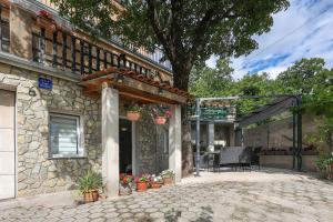 un edificio in pietra con patio con piante in vaso di Apartman Vito a Bakar (Buccari)