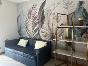 里米尼的住宿－Vespucci Home，客厅配有蓝色的沙发和壁画
