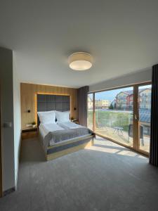 a bedroom with a large bed and a large window at Sea Resort in Władysławowo