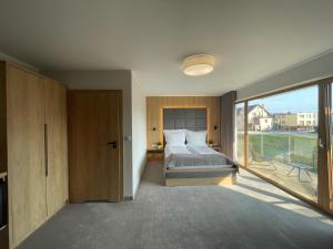 a bedroom with a bed and a large window at Sea Resort in Władysławowo