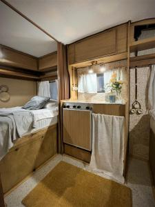 a bedroom with a bed and a kitchen with a stove at Urban Van Glamping Riga in Riga