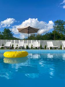 uma piscina com um guarda-sol e uma jangada amarela na água em Green Tianeti em Tʼianetʼi