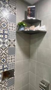 uma casa de banho com um chuveiro em azulejo e uma prateleira em Luxueux Condo - Down town em Marrakech
