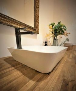 a white bath tub sitting in front of a mirror at Urban Van Glamping Riga in Rīga