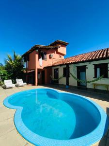 a large blue swimming pool in front of a house at Pousada Dom Quixote in Arraial d'Ajuda