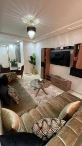 uma sala de estar com um sofá e uma televisão em Luxueux Condo - Down town em Marrakech