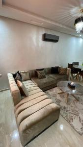 uma sala de estar com um sofá e uma mesa em Luxueux Condo - Down town em Marrakech