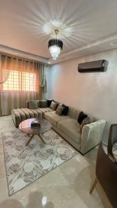 uma sala de estar com um sofá e uma mesa em Luxueux Condo - Down town em Marrakech