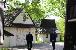 two men walking in front of a building at Zajazd Turystyczny Stara Gawęda in Czechówka