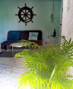 a living room with a couch and a large plant at Mi Otoch en Cancun jardín terraza asador in Cancún