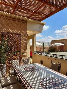un patio con tavolo e sedie sul balcone. di RIAD SHAJARA a Marrakech