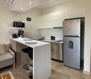 eine Küche mit einem weißen Kühlschrank und einer Theke in der Unterkunft LUXURY CONDO EXCLUSIVE ¨ALDEA ZAMA¨ in Tulum