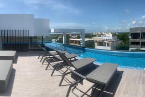 ein Pool auf dem Dach eines Gebäudes in der Unterkunft LUXURY CONDO EXCLUSIVE ¨ALDEA ZAMA¨ in Tulum