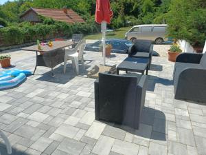 eine Terrasse mit einem Tisch, Stühlen und einem Sonnenschirm in der Unterkunft Gyuszika Vendégház in Balatonfůzfő